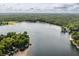 Panoramic aerial view of a serene lake, highlighting the vastness of the water and surrounding lush greenery at 7082 Muskrat Dr, Nineveh, IN 46164