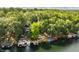 Panoramic aerial view of a lakefront home with docks and tiered patios, surrounded by lush greenery at 7082 Muskrat Dr, Nineveh, IN 46164