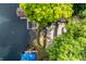 Overhead view of a lake home with tiered stone patios and docks with boats, surrounded by mature trees at 7082 Muskrat Dr, Nineveh, IN 46164