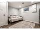 Neutral finished basement room features a daybed, a modern rug, and a small window for natural light at 7082 Muskrat Dr, Nineveh, IN 46164