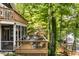 Outdoor deck with a grill, seating, and a view of the lake and surrounding trees at 7082 Muskrat Dr, Nineveh, IN 46164