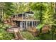 Charming two-story home featuring a screened porch, wooden decks, and beautiful surrounding greenery at 7082 Muskrat Dr, Nineveh, IN 46164