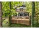 View of a charming home exterior with a multi-level wooden deck and a screen porch surrounded by lush trees at 7082 Muskrat Dr, Nineveh, IN 46164