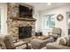 Living room features a stone fireplace with wooden mantel, a TV, and comfortable seating at 7082 Muskrat Dr, Nineveh, IN 46164