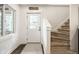 Light-filled foyer featuring carpeted stairs, a decorative door, and hardwood floors at 7082 Muskrat Dr, Nineveh, IN 46164