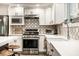 Modern kitchen features stainless steel appliances, white cabinetry, and stylish backsplash at 7082 Muskrat Dr, Nineveh, IN 46164