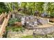 Multi-tiered outdoor living space with stone walls and patio seating, surrounded by mature trees at 7082 Muskrat Dr, Nineveh, IN 46164