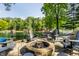 Backyard with stone fire pit and lounge chairs facing calm lake at 7082 Muskrat Dr, Nineveh, IN 46164