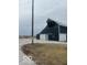 A large, dark metal barn boasts ample storage space and is situated near a gravel driveway at 756 S State Road 13, Lapel, IN 46051