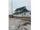 White two-story home features a green roof, complemented by a gravel driveway and minimal landscaping at 756 S State Road 13, Lapel, IN 46051