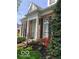 Inviting brick home featuring white columns, black shutters and manicured landscaping leading to the front door at 8044 Clymer Ln, Indianapolis, IN 46250