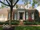 Charming brick home featuring a well-maintained lawn, black shutters and an inviting entryway with a wreath on the front door at 8044 Clymer Ln, Indianapolis, IN 46250