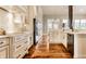 Bright kitchen boasts white cabinets, hardwood floors, marble countertops, and stainless appliances at 8044 Clymer Ln, Indianapolis, IN 46250