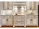 Beautiful kitchen features white cabinets, marble backsplash, under cabinet lights, and stainless appliances at 8044 Clymer Ln, Indianapolis, IN 46250