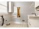 Laundry room with white cabinets, sink, folding table, and blue and white wallpaper at 8044 Clymer Ln, Indianapolis, IN 46250