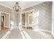 The spacious living room is adorned with natural light, crown molding, a stunning chandelier, and a soft, neutral carpet at 8044 Clymer Ln, Indianapolis, IN 46250