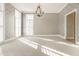 Elegant living room with a chandelier, detailed wallpaper, plantation shutters and neutral carpeting at 8044 Clymer Ln, Indianapolis, IN 46250