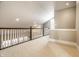 Cozy loft area with neutral walls, carpeted flooring, and views of the staircase at 8044 Clymer Ln, Indianapolis, IN 46250