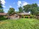 Spacious backyard with a well-maintained lawn, a charming brick home, and a wooden deck at 8316 Hill Gail Dr, Indianapolis, IN 46217