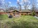 Backyard with wooden deck, patio furniture, well-maintained lawn, and mature trees at 8316 Hill Gail Dr, Indianapolis, IN 46217