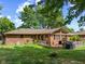 Backyard view showcases a wood deck with furniture, a lawn, an AC unit, and mature trees surrounding the home at 8316 Hill Gail Dr, Indianapolis, IN 46217