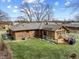 Aerial view of the brick home's backyard with a wood deck, well-maintained lawn, and mature trees at 8316 Hill Gail Dr, Indianapolis, IN 46217