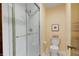 Bright bathroom features a glass enclosed shower with white tile and a standard toilet at 8316 Hill Gail Dr, Indianapolis, IN 46217