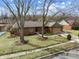Brick home surrounded by mature trees in winter, showcasing a spacious front yard at 8316 Hill Gail Dr, Indianapolis, IN 46217