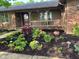 Charming single-story home featuring a brick and wood facade with lush landscaping in the front yard at 8316 Hill Gail Dr, Indianapolis, IN 46217