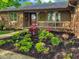 Charming single-story home featuring a brick and wood facade with lush landscaping in the front yard at 8316 Hill Gail Dr, Indianapolis, IN 46217