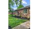 Beautifully landscaped front yard with lush green grass, decorative plants, and a well-maintained garden bed at 8316 Hill Gail Dr, Indianapolis, IN 46217