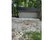 A storage shed exterior with neutral siding and a dark roof is surrounded by stones and greenery at 8381 S Kinman Dr, , IN 46164