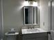 Modern bathroom sink with a sleek mirror, vanity lights, and white cabinets at 104 Walnut Ct, Noblesville, IN 46062