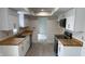 Bright kitchen features white cabinets, stainless steel sink with wood countertop, and modern black appliances at 104 Walnut Ct, Noblesville, IN 46062