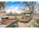 Landscaped backyard with mature trees and a stone-lined flower bed at 114 E Mill St, Brooklyn, IN 46111