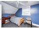 Bedroom features a wood bed frame, blue walls and a ceiling fan at 114 E Mill St, Brooklyn, IN 46111