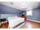 Cozy bedroom with blue walls, hardwood floors, and a comfortable bed at 114 E Mill St, Brooklyn, IN 46111