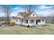 Well-kept two-story home with charming front porch, ample lawn space, and mature landscaping at 114 E Mill St, Brooklyn, IN 46111
