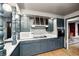 Eat-in kitchen featuring custom blue cabinets, mosaic backsplash, modern appliances, and wood floors at 114 E Mill St, Brooklyn, IN 46111