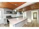 Modern kitchen with stainless appliances, large center island, and warm wood paneled ceiling at 117 W Mckenzie Rd, Greenfield, IN 46140