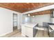 Bright kitchen island with gray cabinets, quartz counter and hardwood-style flooring and adjacent closet at 117 W Mckenzie Rd, Greenfield, IN 46140