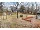 Expansive backyard featuring a trampoline, mature trees and access to brick patio at 122 S Green St, Brownsburg, IN 46112