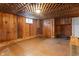 Unfinished basement with wood paneling, tiled floors, and a brown wooden door at 122 S Green St, Brownsburg, IN 46112