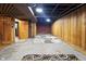 Basement area featuring paneled walls and exposed ceiling with brick accent wall at 122 S Green St, Brownsburg, IN 46112