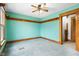 Bedroom features teal walls, wood trim, carpeted floors, and a ceiling fan at 122 S Green St, Brownsburg, IN 46112