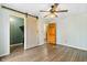 Bedroom features light green walls, wood floors, a sliding barn door, and ceiling fan at 122 S Green St, Brownsburg, IN 46112