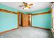 Bedroom features teal walls, wood trim, carpeted floors, and a ceiling fan at 122 S Green St, Brownsburg, IN 46112