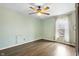 Bedroom features light green walls, wood floors, a ceiling fan, and a window at 122 S Green St, Brownsburg, IN 46112