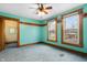 Bedroom features teal walls, wood trim, carpeted floors, two windows, and a ceiling fan at 122 S Green St, Brownsburg, IN 46112