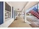 Charming front porch of a home with a swing, an American flag, and bright blue shutters and door at 122 S Green St, Brownsburg, IN 46112